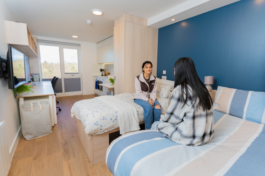 Two students sitting on twin beds
